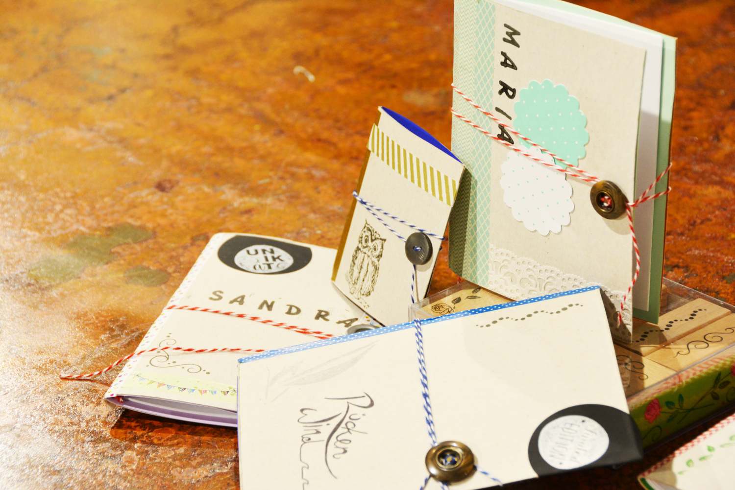 Mehrere aus Müslikarton gestaltete Notizbücher liegen und stehen auf einem Tisch.