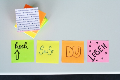 4 bunte Post-its, jeweils mit einem Wort beschrieben, ergeben zusammen den Spruch "Hoch sollst du leben"