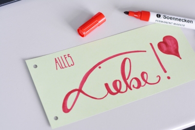 Auf einem Trennstreifen mit rotem edding gelettert "Alles Liebe"
