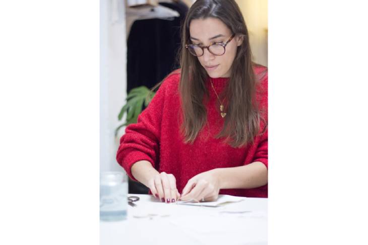 Yasmin von May & Berry in rotem Pullover bastelt konzentriert an DIY-Karte