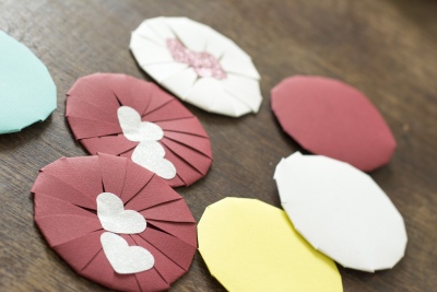 Runde Papierblüten, welche mit einem Herz zugeklebt sind