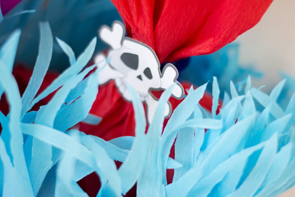 Nahaufnahme des blauen Krepppapiers der Schultüte sowie eines Totenkopf-Elements