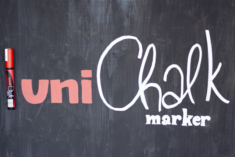Tafel mit Schriftzug „uni Chalk marker“ und rotem Kreidestift