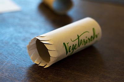 Papierrolle mit Aufschrift „Vegetarisch“ auf Holztisch, als DIY-Idee.
