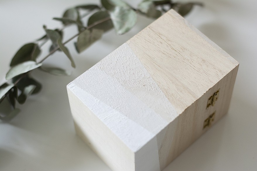 Holzbox mit weißem geometrischen Muster neben Eukalyptuszweig