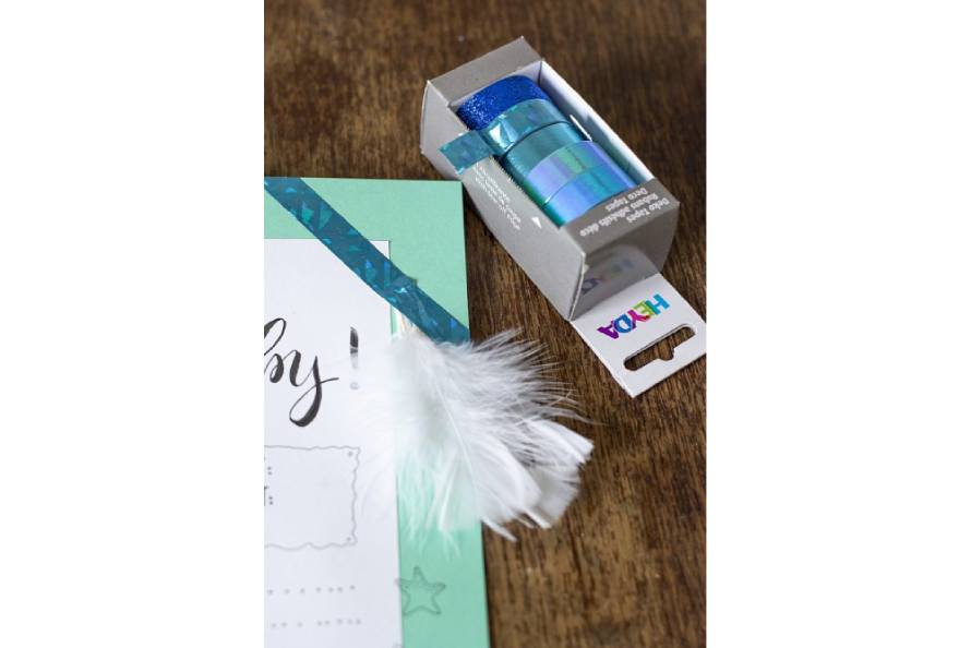 Glitzerndes Deko-Tape von Heyda und weiße Feder auf Babyspielkarte