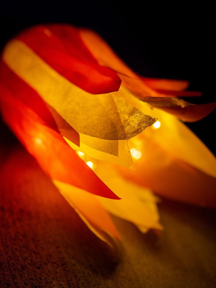 Eine Fackel aus PET-Flaschen, deren innenliegende Lichterkette hell leuchtet.