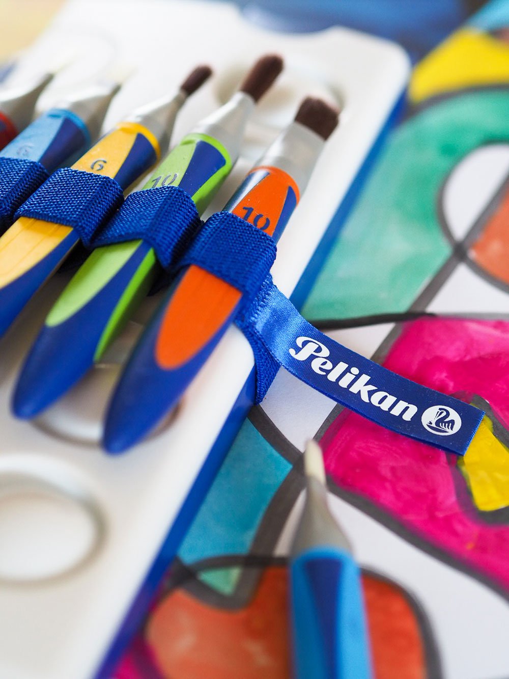 griffix-Pinsel werden mit Gummiband am Pelikan Farbkasten festgehalten.