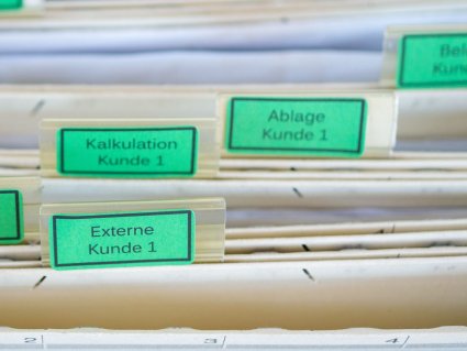Hängeregister mit grünen Etiketten für Kundenprojekte.