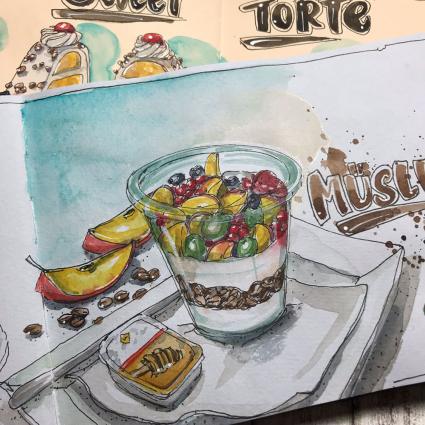 Auf weißes Papier wurde mit Aquarell ein Glas mit Müsli und Früchten gemalt. Das Glas steht auf einem Teller. Daneben ist eine Packung Honig gemalt. Im Hintergrund sieht man Müsli und Apfelstücke. Im Hintergrund sieht man ein weiteres Aquarell-Motiv mit Torten. 