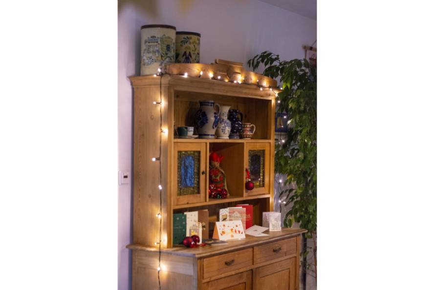 Buffetschrank mit Weihnachtskarten und Lichterkette in weihnachtlicher Deko.