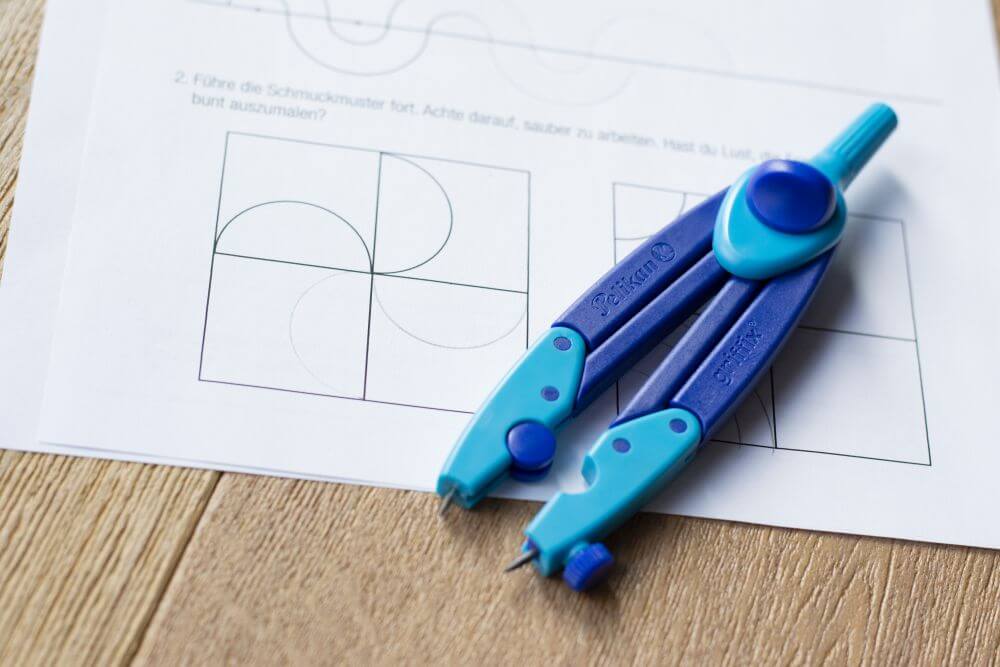 Auf einem Übungsblatt zum Thema "Zirkel: Übungen für die 4. Klasse" liegt der Schulzirkel griffix von Pelikan.