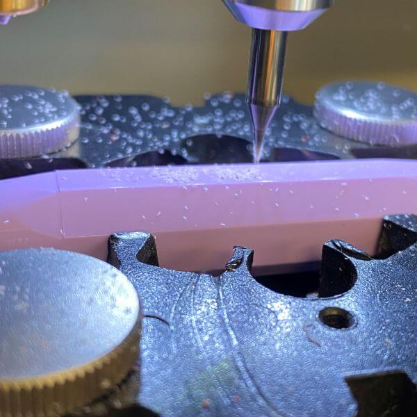 Nahaufnahme eines Füllers der Marke Kaweco, das in einer Graviermaschine mit Fräsgravur graviert wird.