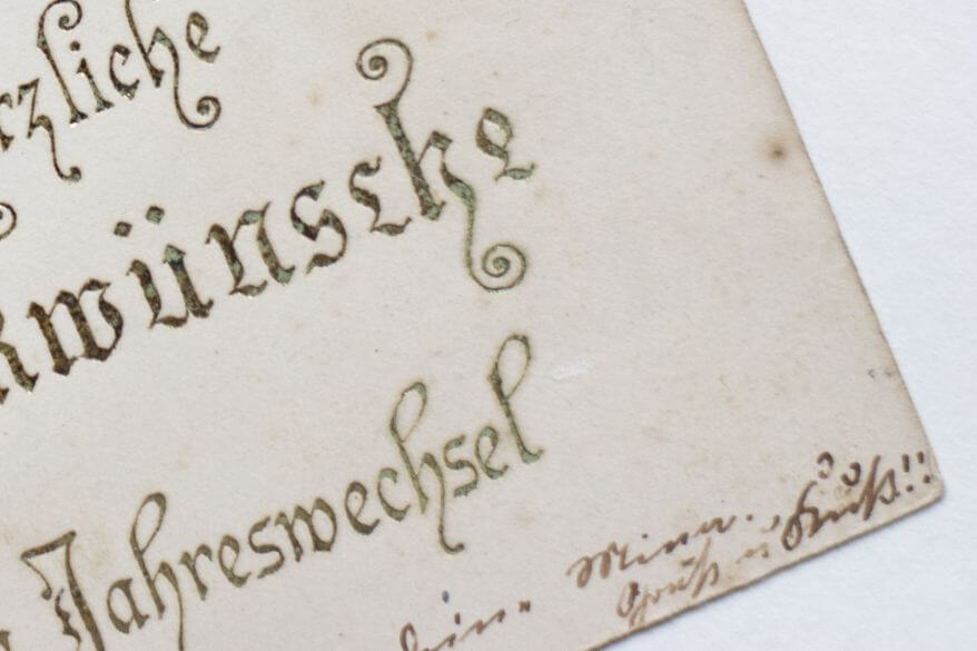 Detailaufnahme einer historischen Postkarte mit kleinem, handschriftlichem Vermerk in der Ecke.