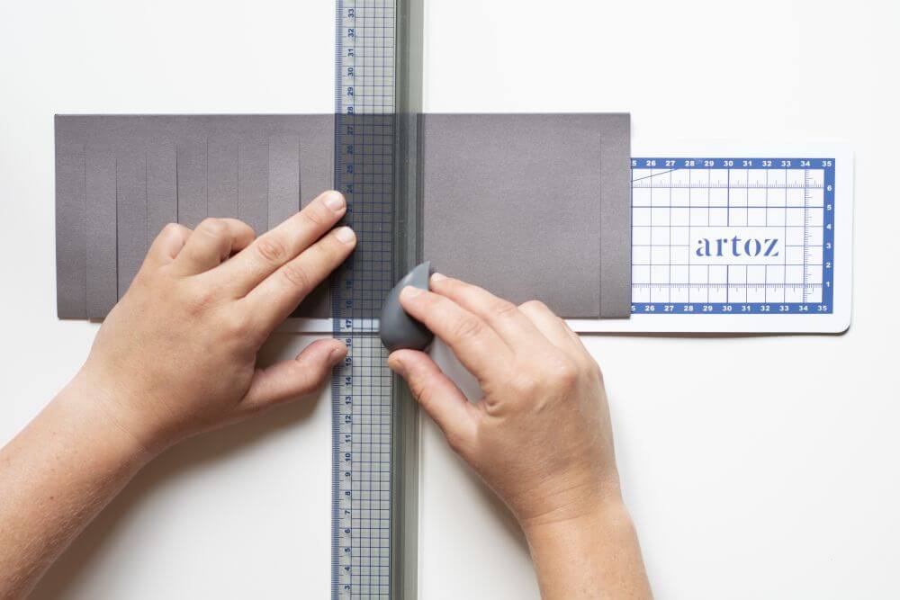 Laterne basteln aus Papier, Bastelanleitung Schritt 2: Schneiden Sie Streifen mit einer Breite von 1,5 Zentimetern in das Papier ein. Beginnen Sie an der Falz.