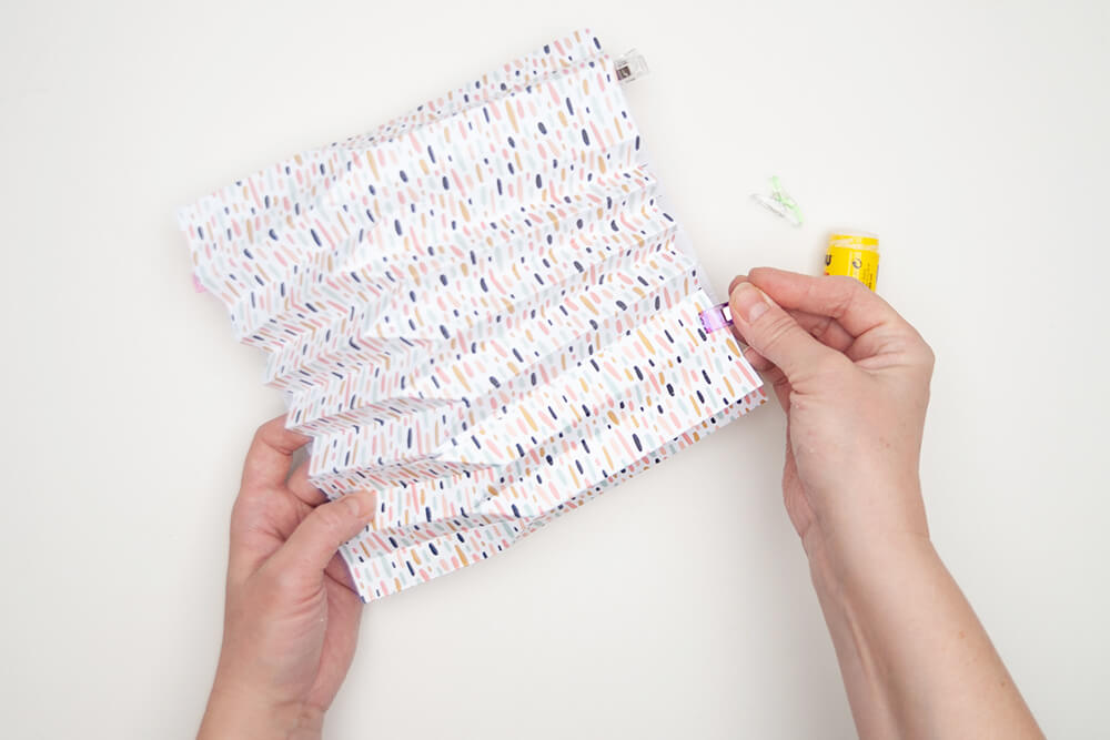 Pappvase: Zwei im Plissee gefaltete Designpapiere von Artoz werden an den Klebestellen mit Klammern fixiert.