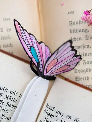 Im Schnitt eines Buches steckt ein mit Stiften von STAEDTLER gestaltetes Lesezeichen in Schmetterlingsform. Foto: Johanna Rundel