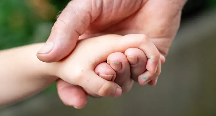 Eine alte und eine Kinderhand greifen ineinander. Foto: Johanna Rundel