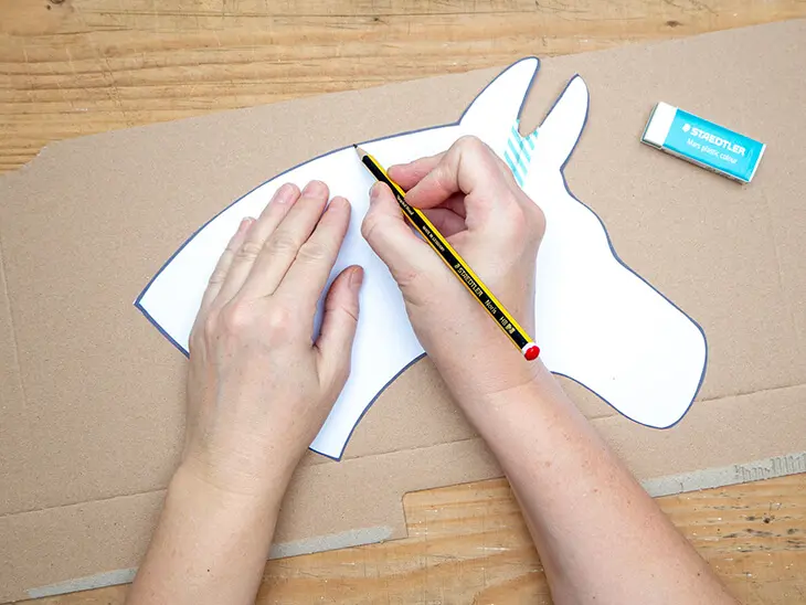 Jemand zeichnet mit einem Bleistift von STAEDTLER den Umriss eines Pferdekopfes auf einen Karton ab. Foto: Johanna Rundel)