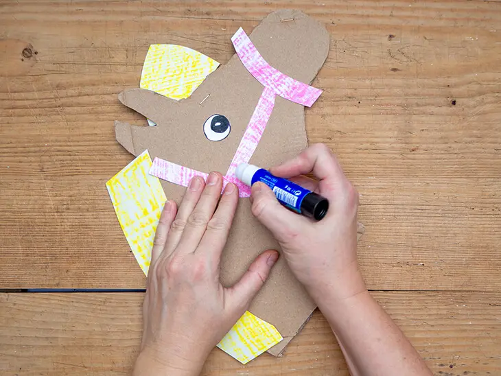 Jemand klebt ein Halfter aus Papier auf einem Pferdekopf aus Pappe. Foto: Johanna Rundel