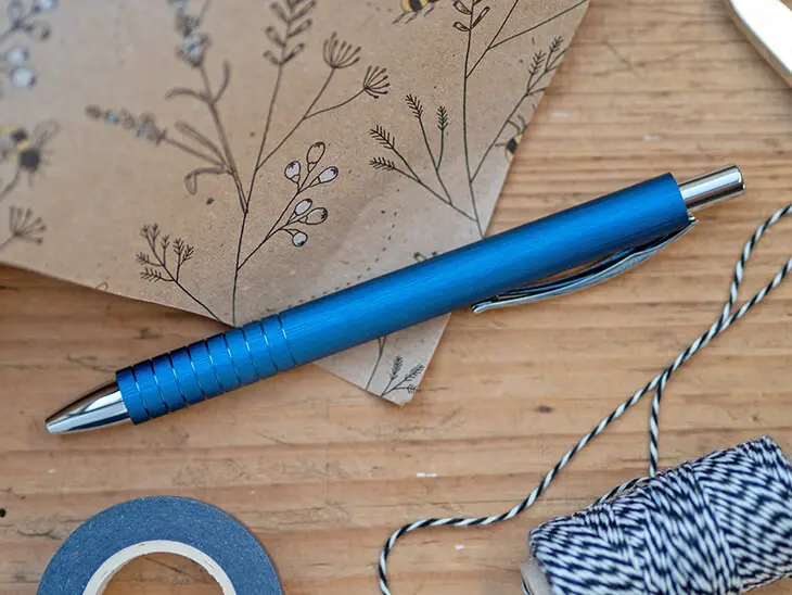 Ein blauer Kugelschreiber von Faber-Castell liegt zwischen Geschenkpapier. Foto: Johanna Rundel
