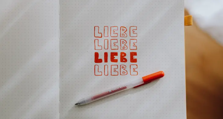 Blick in ein aufgeschlagenes Notizbuch, in das vier Mal das Wort „Liebe“ mit einm Gelly Roll von Sakura geschrieben wurde