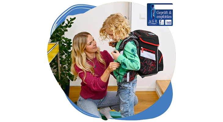 Eine Frau verstellt den Träger eines Schulranzens, den ein Kind am Rücken trägt-