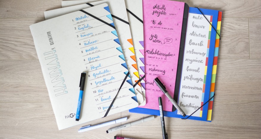 Verschiedene Ordnungsmappen von Pagna wurden belettert. Darauf liegen einige Text- und Fasermaler.