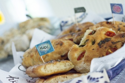 In einer blauen Schüssel liegen zahlreiche Canapés. In diese wurden Zahnstocher gestochen, die mit Fähnchen aus Washitape beklebt wurden. Auf einem ist das Wort "nice" zu lesen.