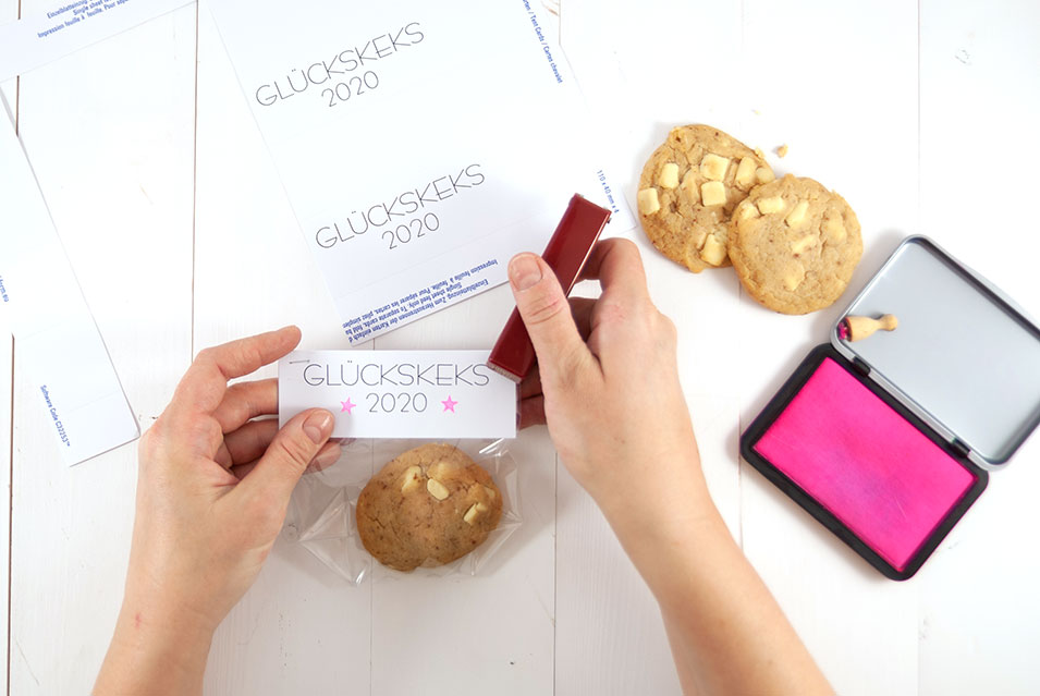 Etikett wird auf Keks-Tüte geheftet