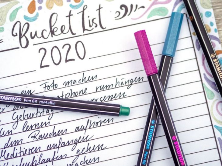 Ein Close-up einer Bucket List für das Jahr 2020. Diese wurde mit Metallic Markern von Stabilo verziert. Auf der Liste sind bereits einige Punkte eingetragen. Darauf liegen einige Stifte von Stabilo.