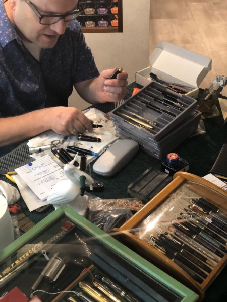 Jürgen Kuhse in seiner Werkstatt am arbeiten. Auf dem Tisch liegen Pelikan Füller.