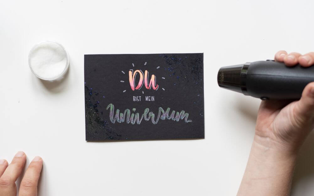 Anleitung Blending mit Gelstiften (Gelly Rolls von Sakura), Schritt 5: Mit Embossing glitzernde Deko in die Ecken der Karte setzen.