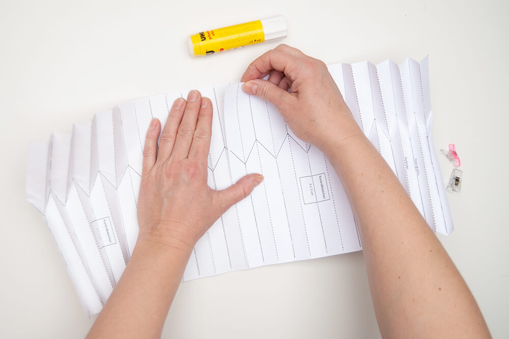 Pappvase: Zwei im Plissee gefaltete Designpapiere von Artoz werden überlappend zusammengeklebt.