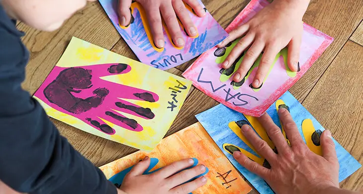 Mehrere Kinder drücken Ihre Handflächen auf mit Materialien von STAEDTLER bunt gestaltete Bilder. Foto: Johanna Rundel