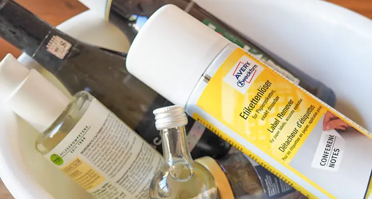 Eine Sprühdose Etikettenlöser von Avery Zweckform liegt in einer Schüssel mit Glasflaschen. Foto: Johanna Rundel