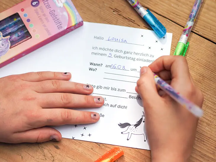 Jemand füllt mit einem Glitzer-Gelstift von Coppenrath eine Geburtstagseinladung aus. Foto: Johanna Rundel)