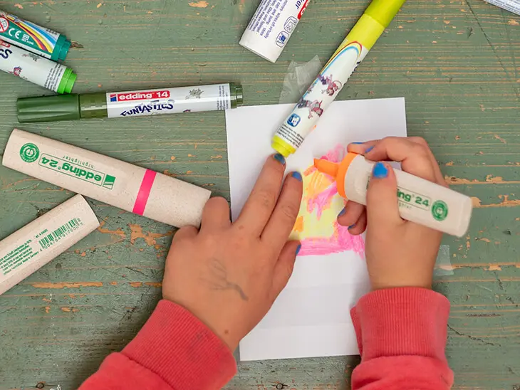 Ein Kind malt mit Textmarkern von edding eine Weihnachtskarte aus. Foto: Johanna Rundel