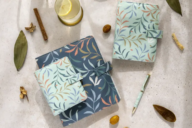 Auf einem Tisch liegen Organizer von Filofax mit floralem Muster in unterschiedlichen Größen