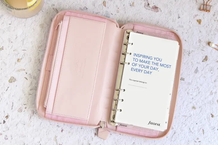 Ein aufgeschlagener Planer von Filofax liegt auf einem Tisch