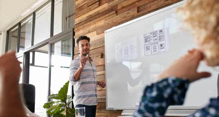 Mann präsentiert an Legamaster Whiteboard in modernem Meetingraum.