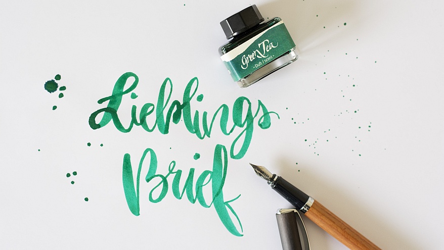 Handschrift „Lieblingsbrief“ in grüner Tinte mit Füllhalter und Tintenfass der Marke Online