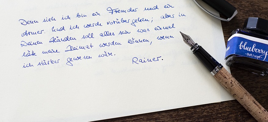 Handgeschriebener Brief in blauer Tinte mit Kork-Füllhalter und Tintenass der Marke Online