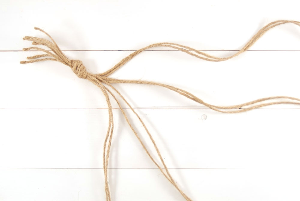 Mehrere zusammengeknotete Kordelenden liegen auf einem Tisch