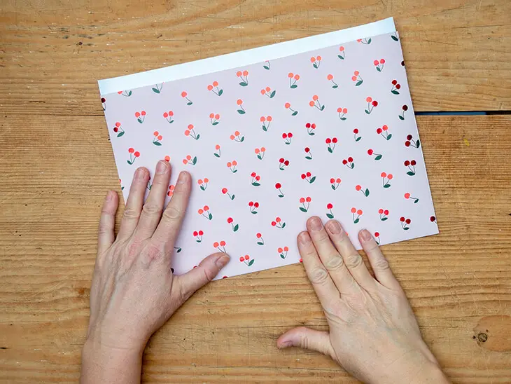 Jemand faltet ein rechteckiges Geschenkpapier von STEWO mittig. Foto: Johanna Rundel