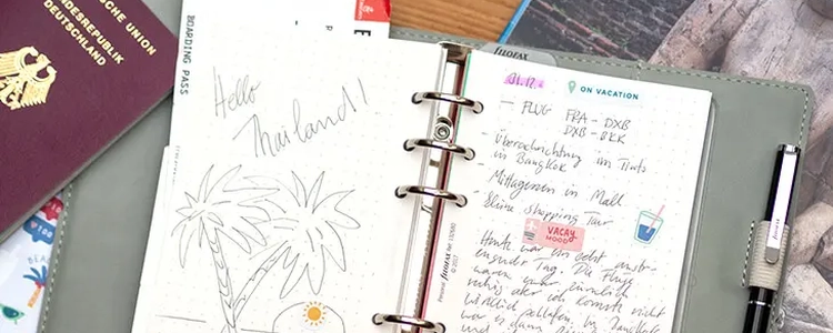 Ein Filofax Reisetagebuch liegt zwischen Landkarte und Reisepass. Foto: Johanna Rundel