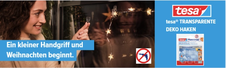 Eine Frau klebt eine Lichterkette an die Scheibe.
